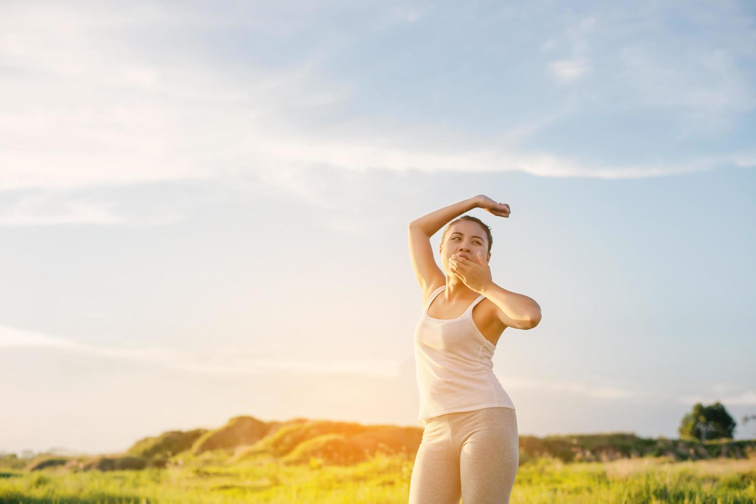 Belles jeunes femmes de yoga étend ses mains et bâille le matin photo