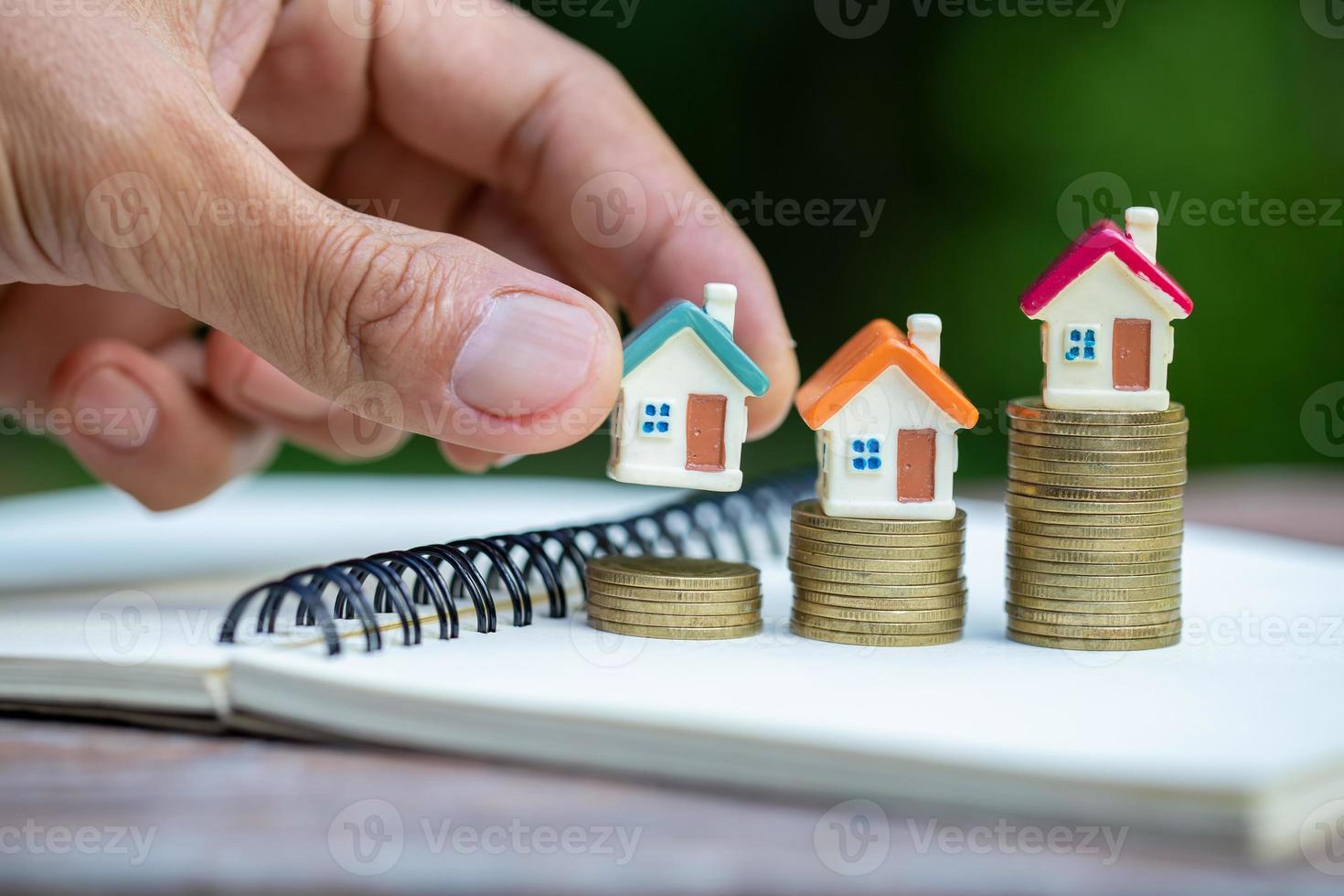 mains tenant un modèle de maison. plan hypothécaire de l'industrie du logement et stratégie d'économie d'impôt résidentiel, concept d'hypothèque, d'investissement, d'immobilier et de propriété photo