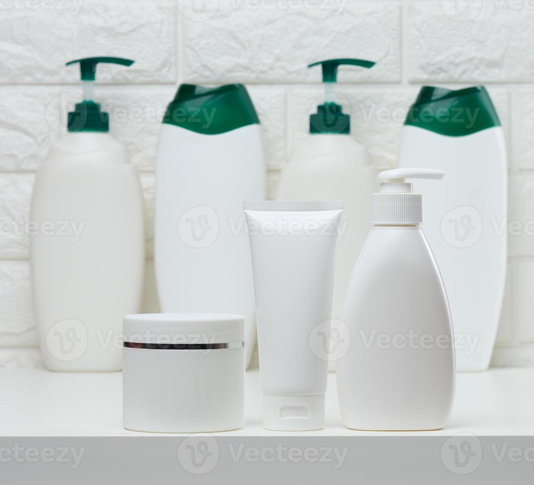 pots et tubes en plastique blanc pour cosmétiques liquides sur fond blanc. image de marque, publicité photo