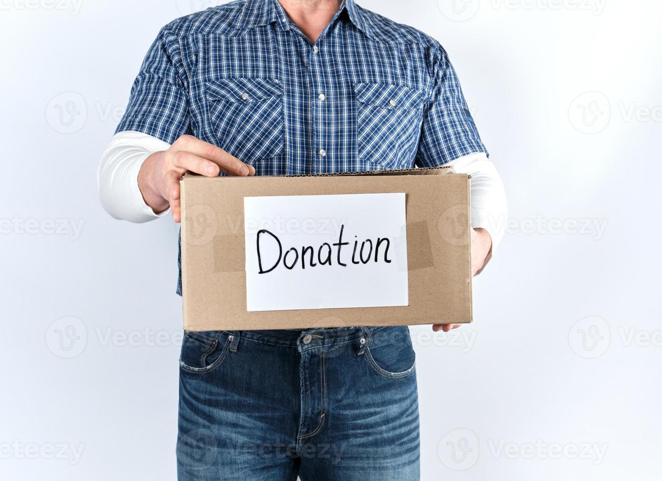 homme en vêtements décontractés tenant une boîte en papier brun avec le don d'inscription photo