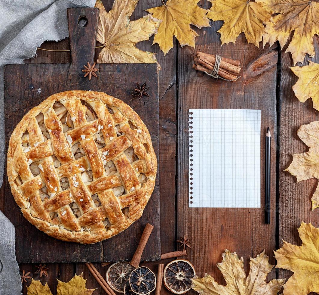 toute la tarte aux pommes ronde cuite sur une planche de bois marron photo