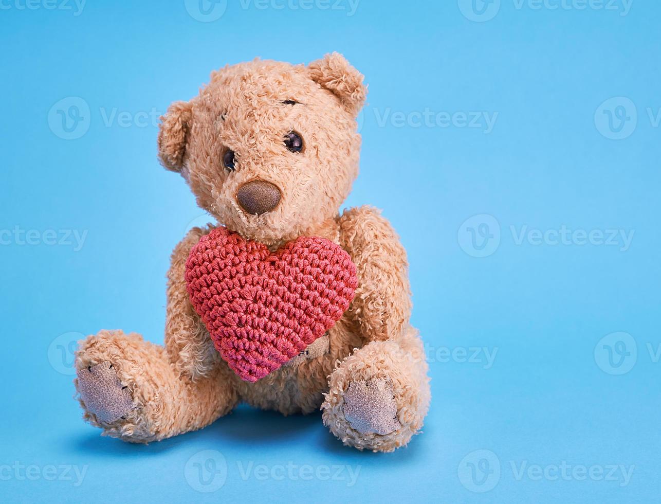 petit ours en peluche tenant un coeur rouge photo