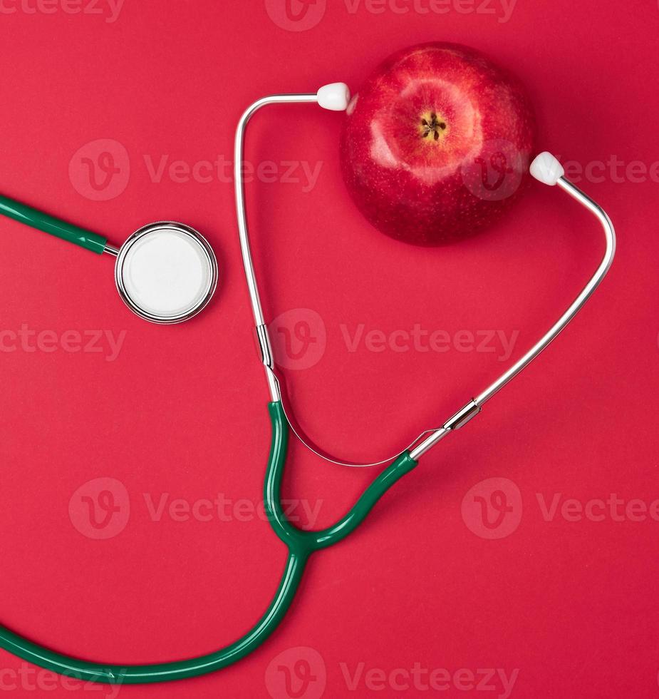 pomme mûre et stéthoscope médical vert photo