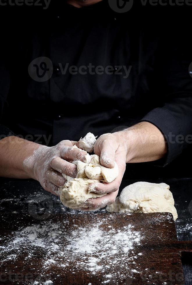 boulanger pétrit la pâte de farine de blé blanc photo