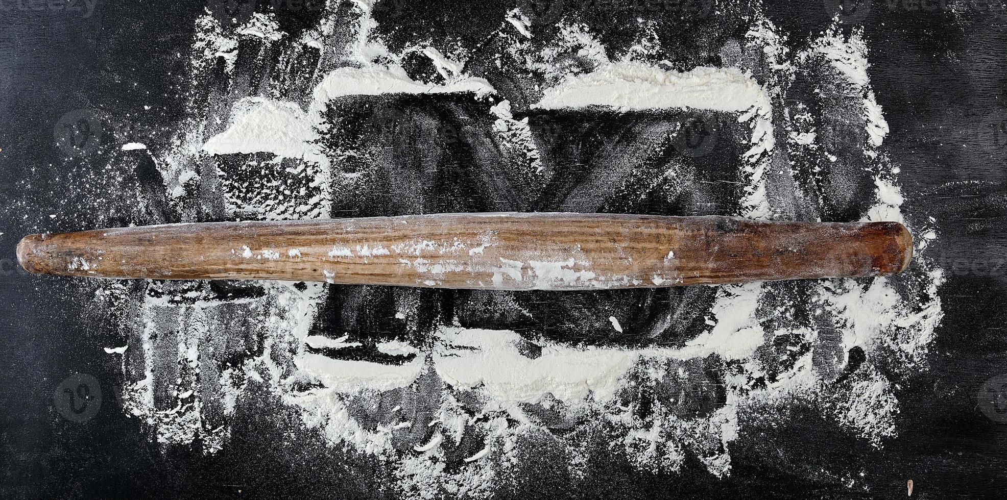 rouleau à pâtisserie en bois très ancien sur fond noir photo