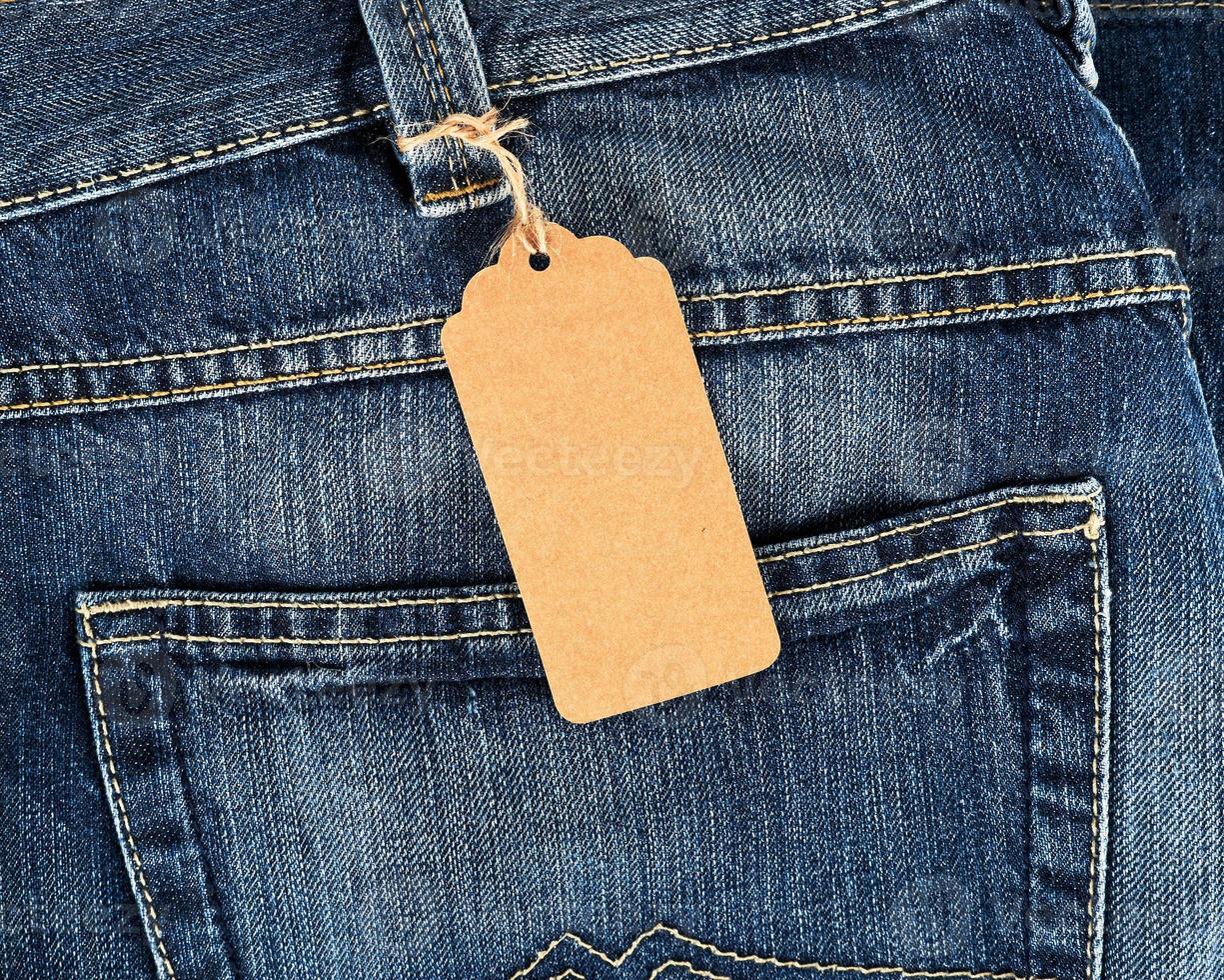 Étiquette vierge marron attachée sur un jean bleu photo