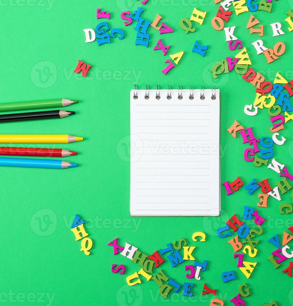 cahier avec des feuilles blanches vides et des crayons en bois multicolores photo