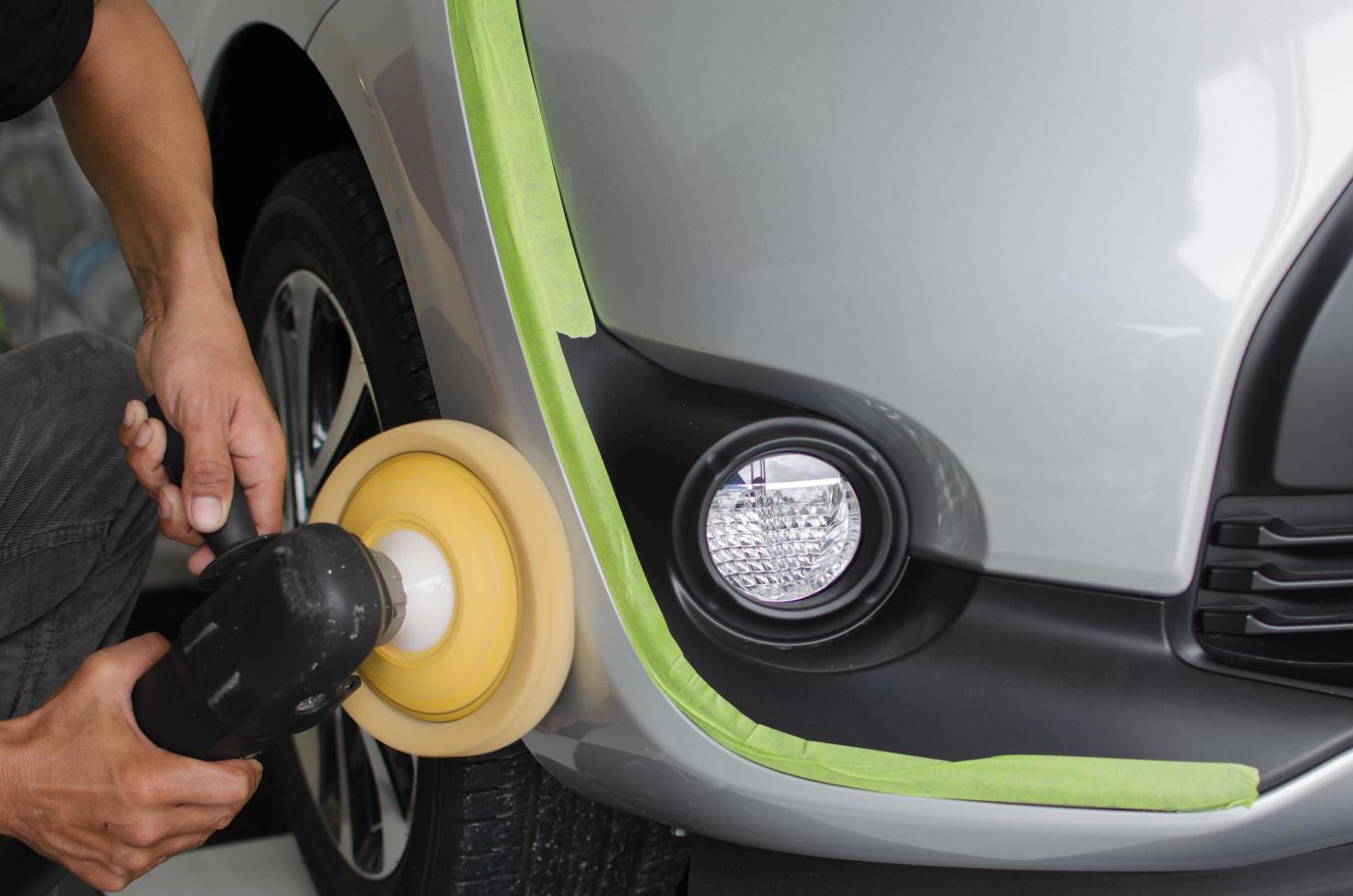 mains polissant une voiture noire photo