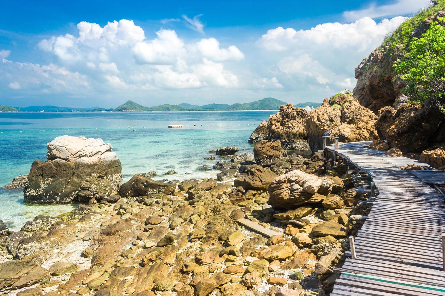 Pont de roche et de bois de l'île tropicale sur la plage avec ciel bleu nuageux photo