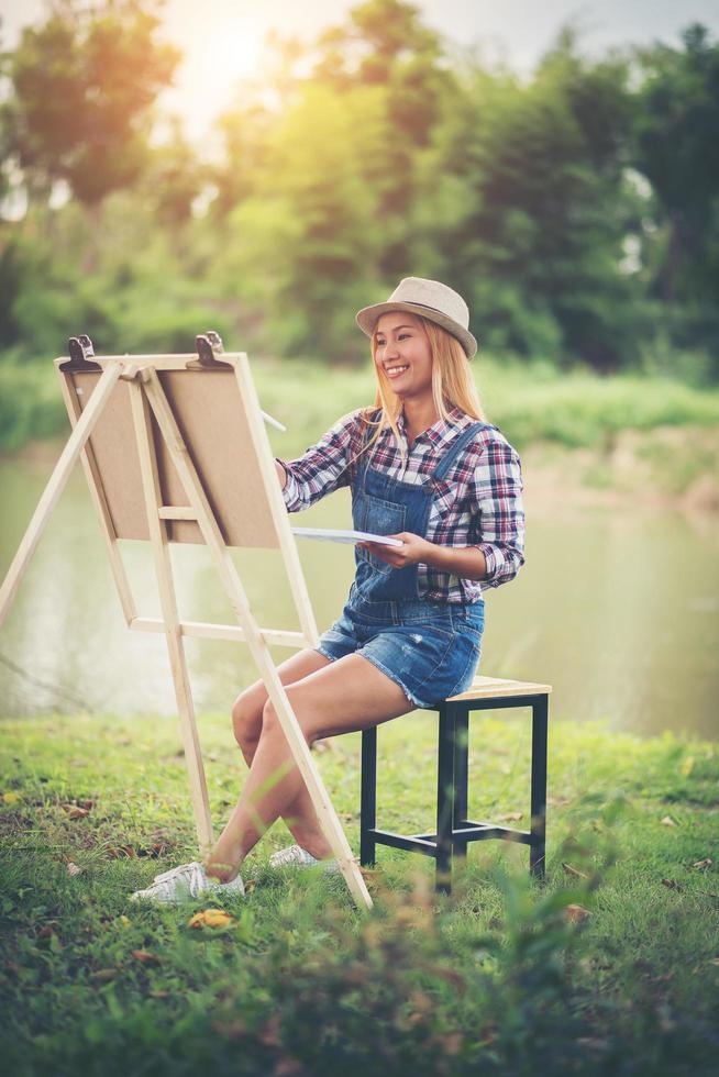 jeune femme dessine une image dans le parc photo
