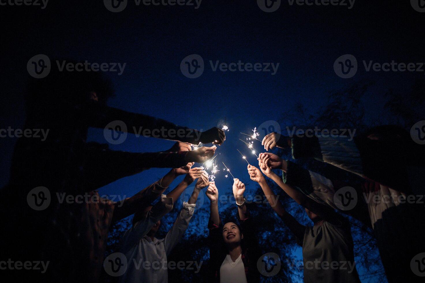 groupe de jeunes amis tenant et jouant avec des cierges magiques photo