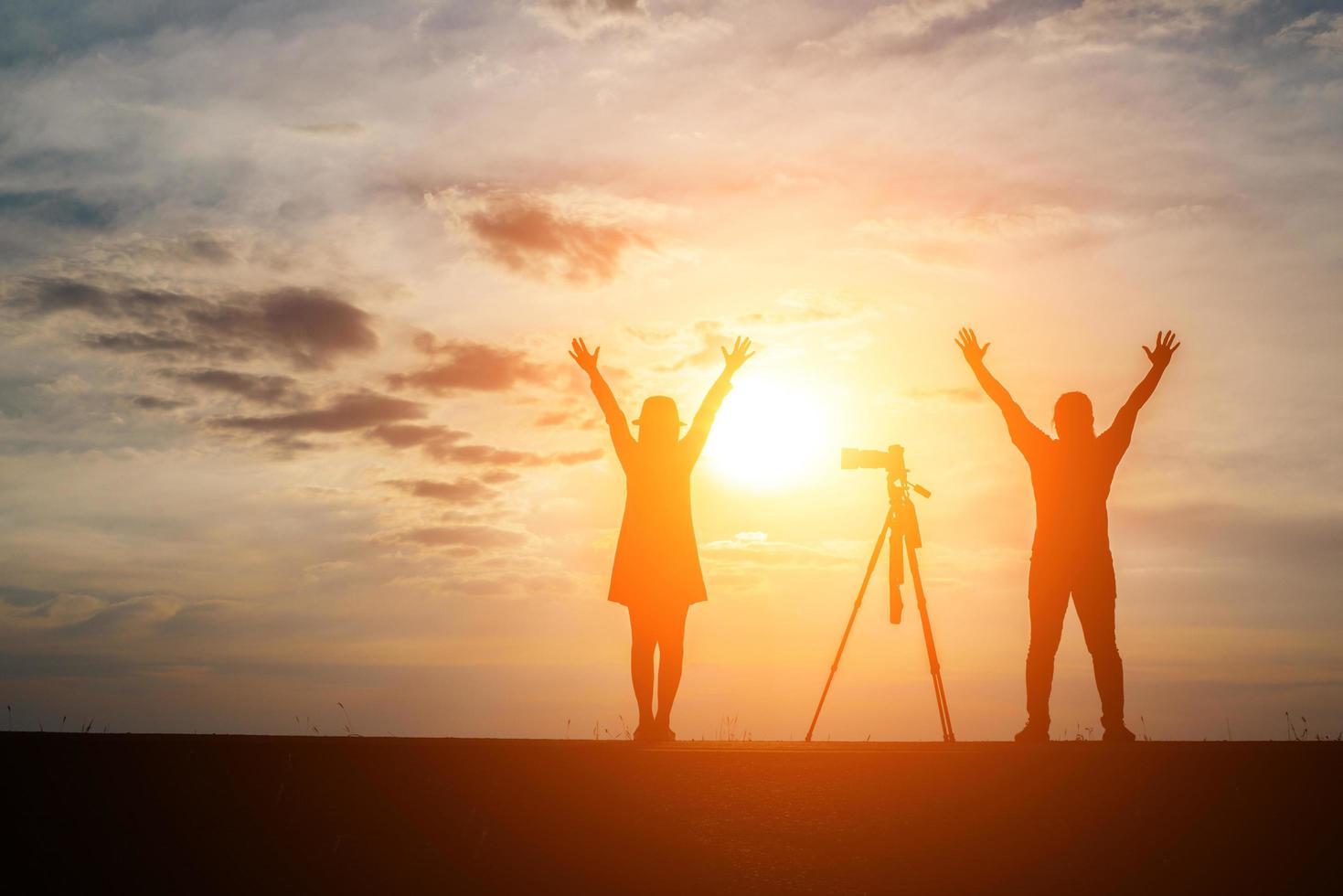 silhouette d'un photographe avec modèle et appareil photo au coucher du soleil