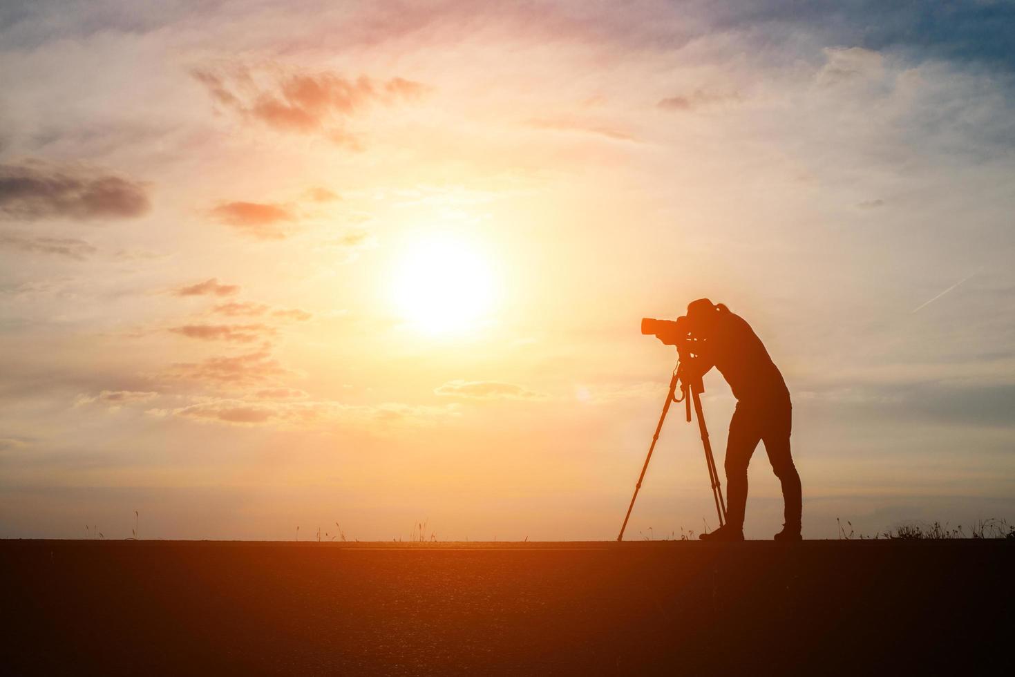 silhouette d'un photographe tirant au coucher du soleil photo