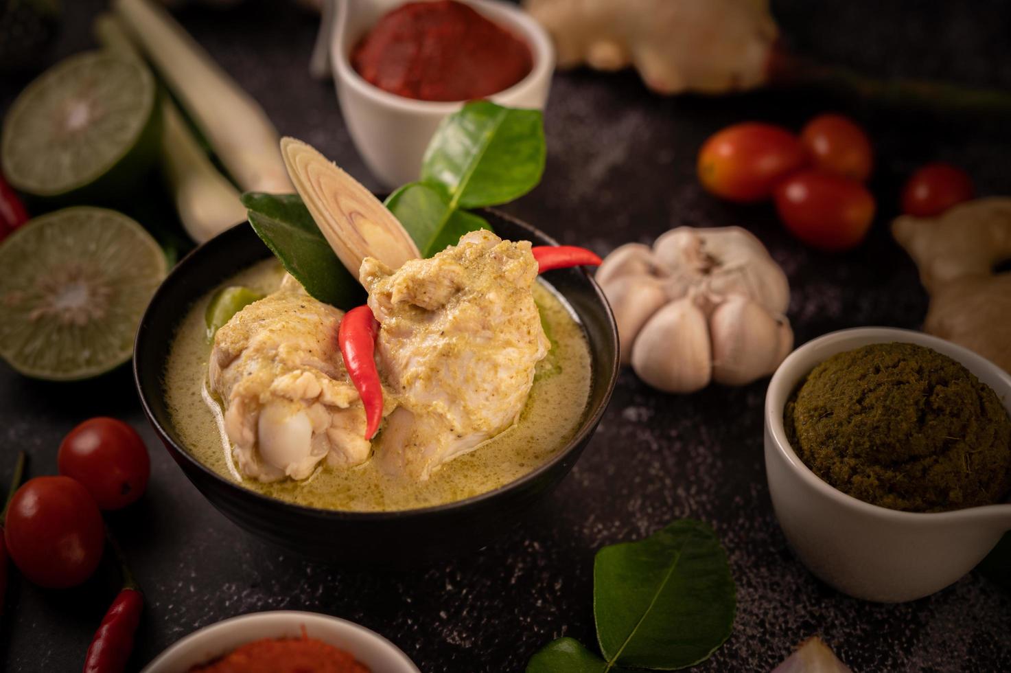 plat de curry vert avec poulet, chili et basilic et tomate et citron vert photo