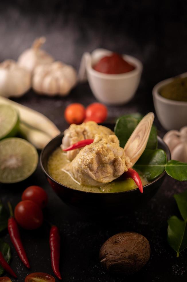 plat de curry vert avec poulet, chili et basilic et tomate et citron vert photo