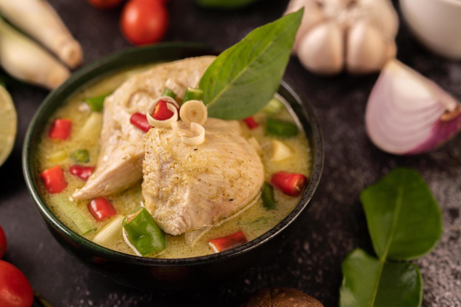 plat de curry vert avec poulet, chili et basilic et tomate et citron vert photo