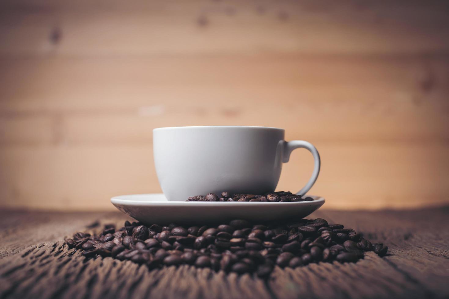 tasse à café avec des grains de café sur une table en bois photo