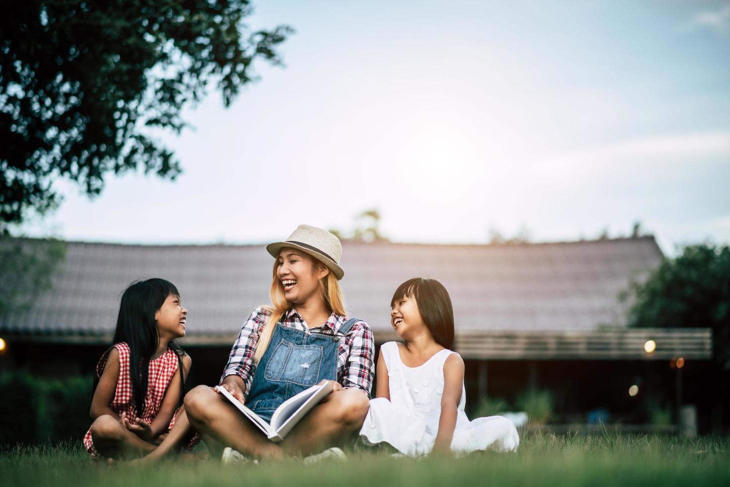 mère racontant une histoire à ses deux petites filles dans le jardin potager photo