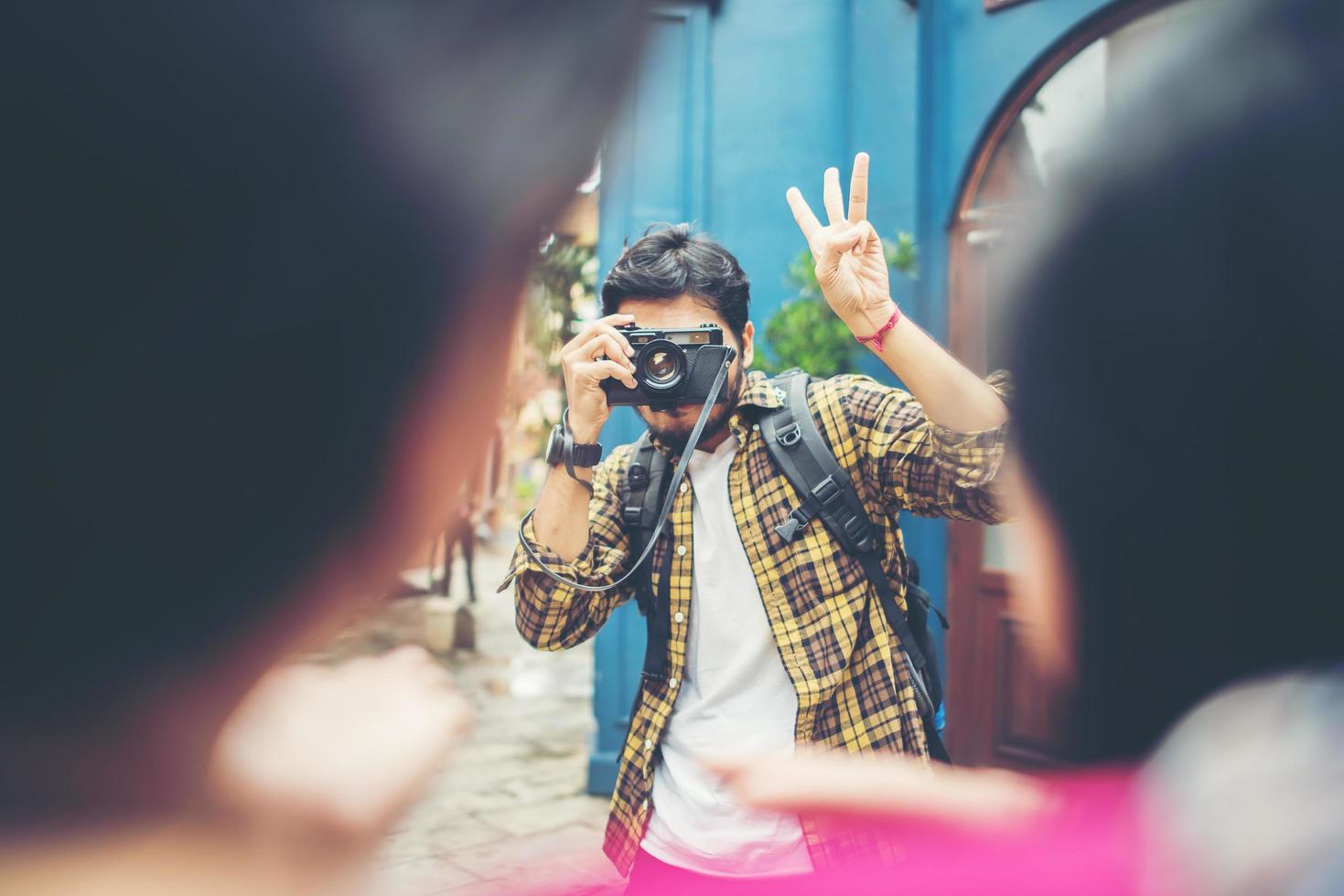 Jeune homme prenant des photos de ses amis lors d'un voyage en zone urbaine ensemble