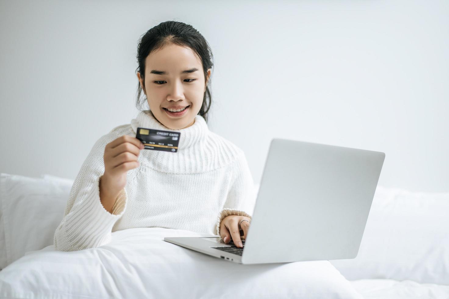 jeune femme, achats, sur, ordinateur portable, et, tenue, a, carte crédit photo