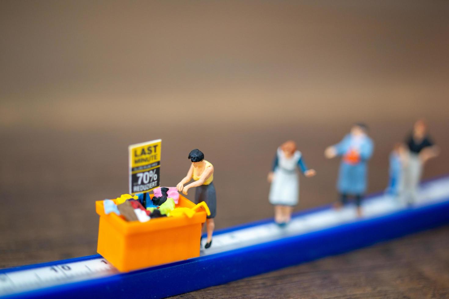 personnes miniatures faisant du shopping dans un bac à rabais photo