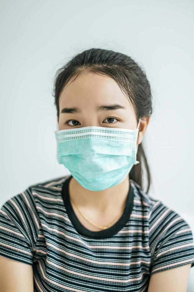 une femme portant une chemise rayée et un masque de protection photo