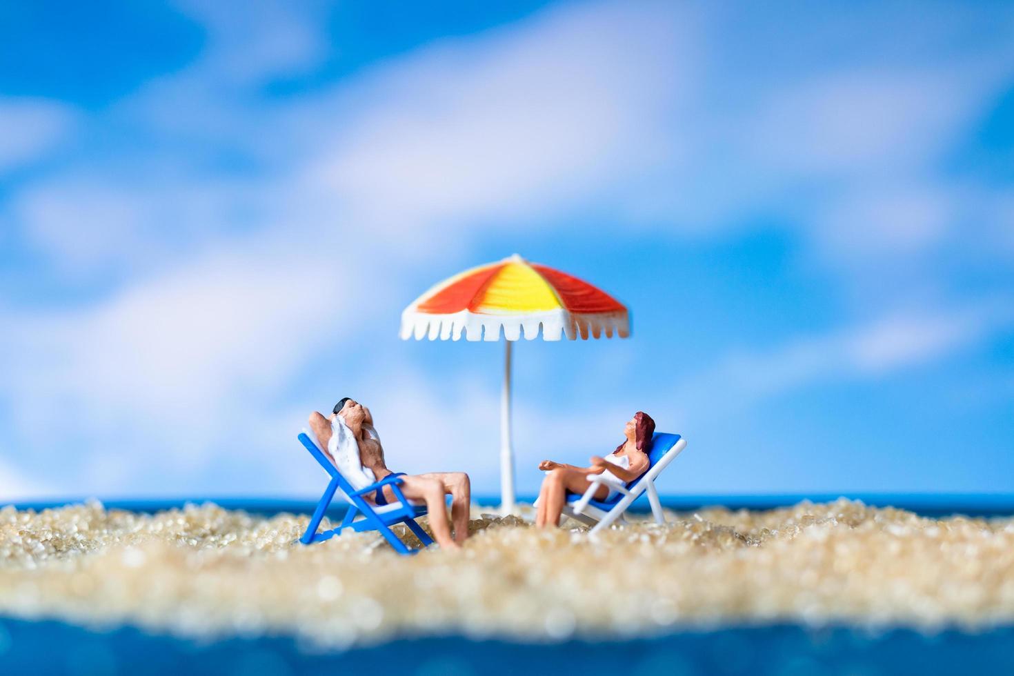 figurines miniatures assis sur la plage photo