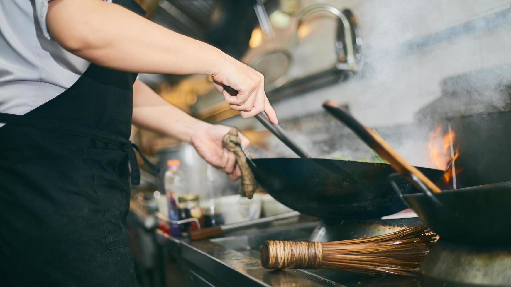 cuisinier travaillant avec wok photo