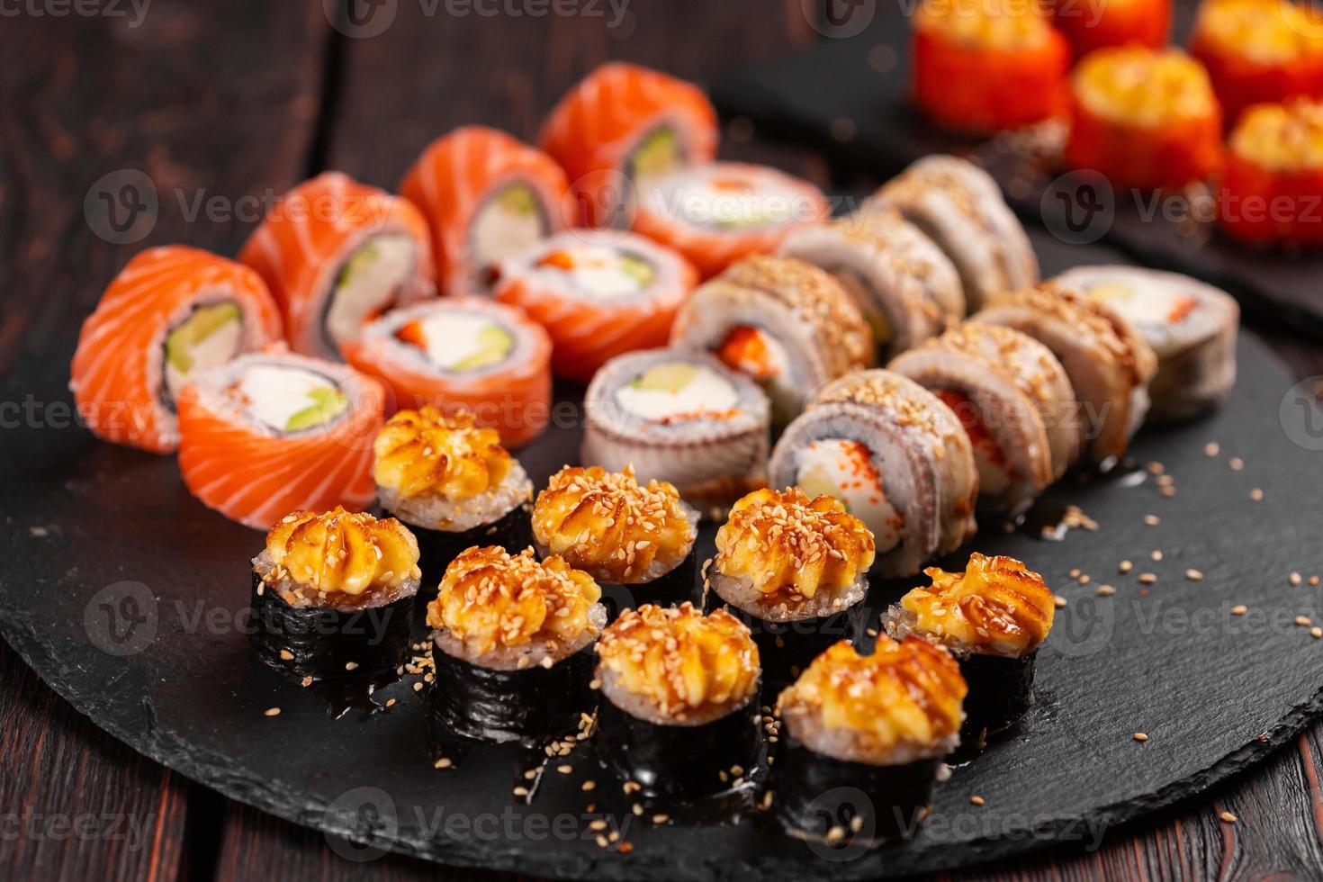 petits pains sertis de crevettes de poisson et de sushis au caviar avec des baguettes - concept de cuisine asiatique et de cuisine japonaise photo