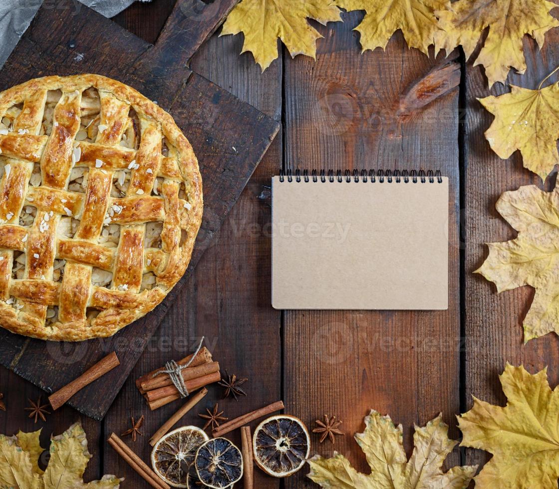 toute la tarte aux pommes ronde cuite sur une planche de bois marron photo