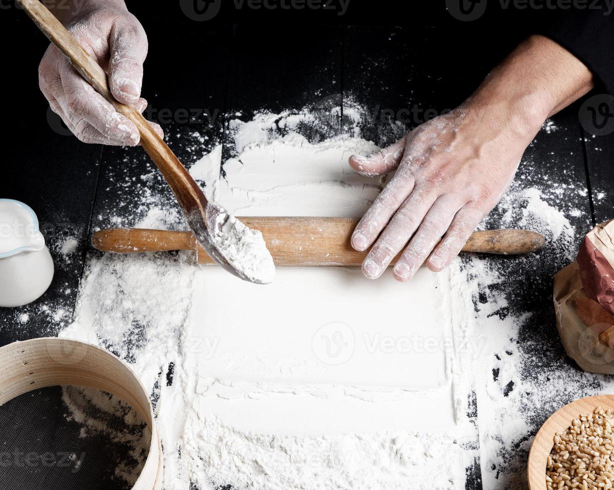 rouleau à pâtisserie en bois dans les mains des hommes photo