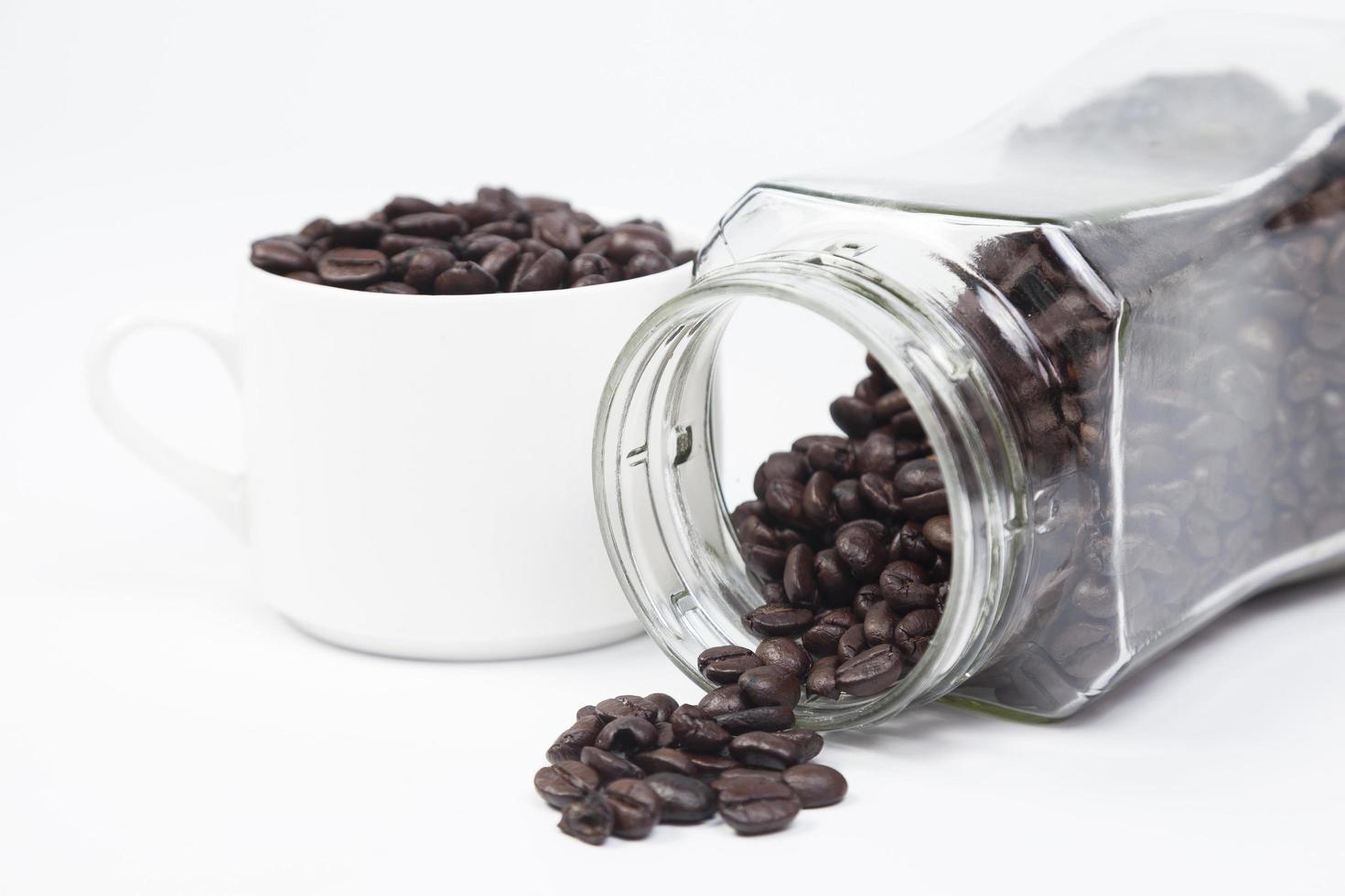 tasse avec des grains de café sur fond blanc photo