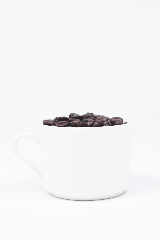 tasse avec des grains de café sur fond blanc photo