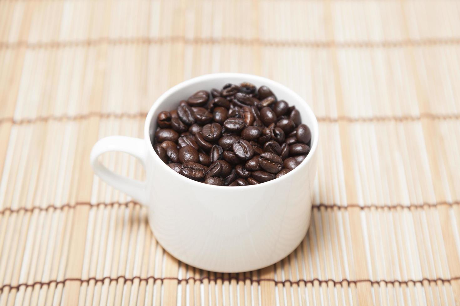 grains de café torréfiés dans une tasse photo