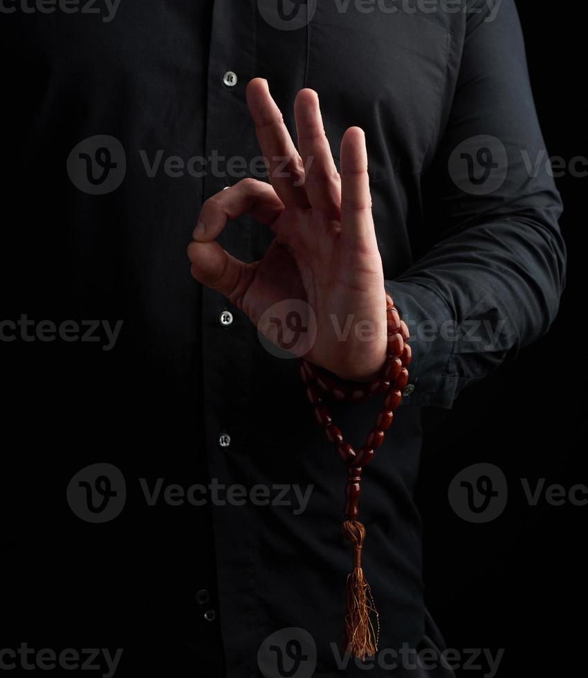 homme en chemise noire montre avec sa main gauche le gian mudra photo