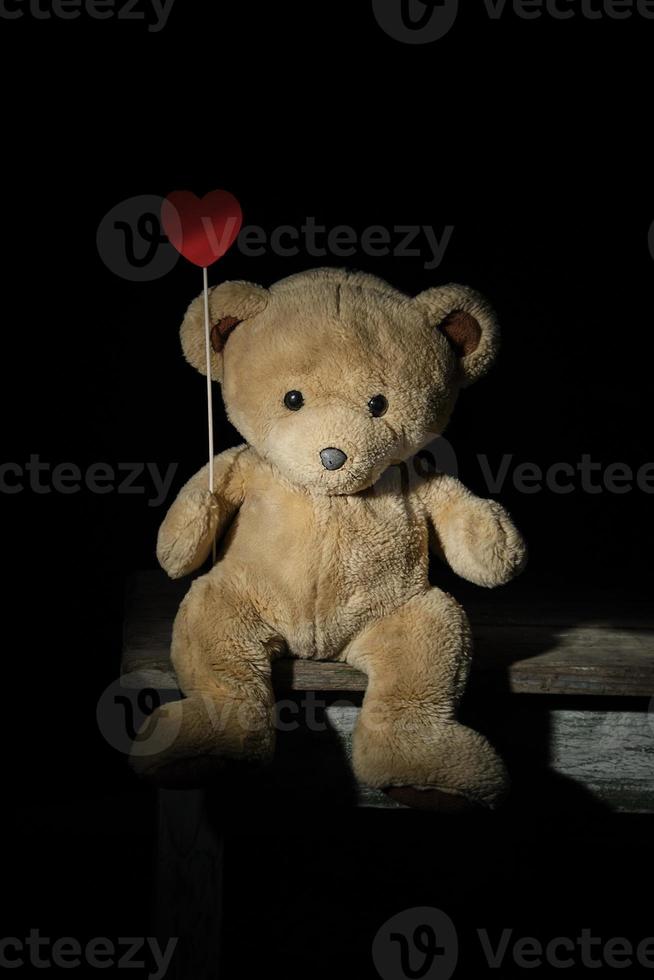 ours en peluche brun solitaire est assis sur une chaise en bois photo