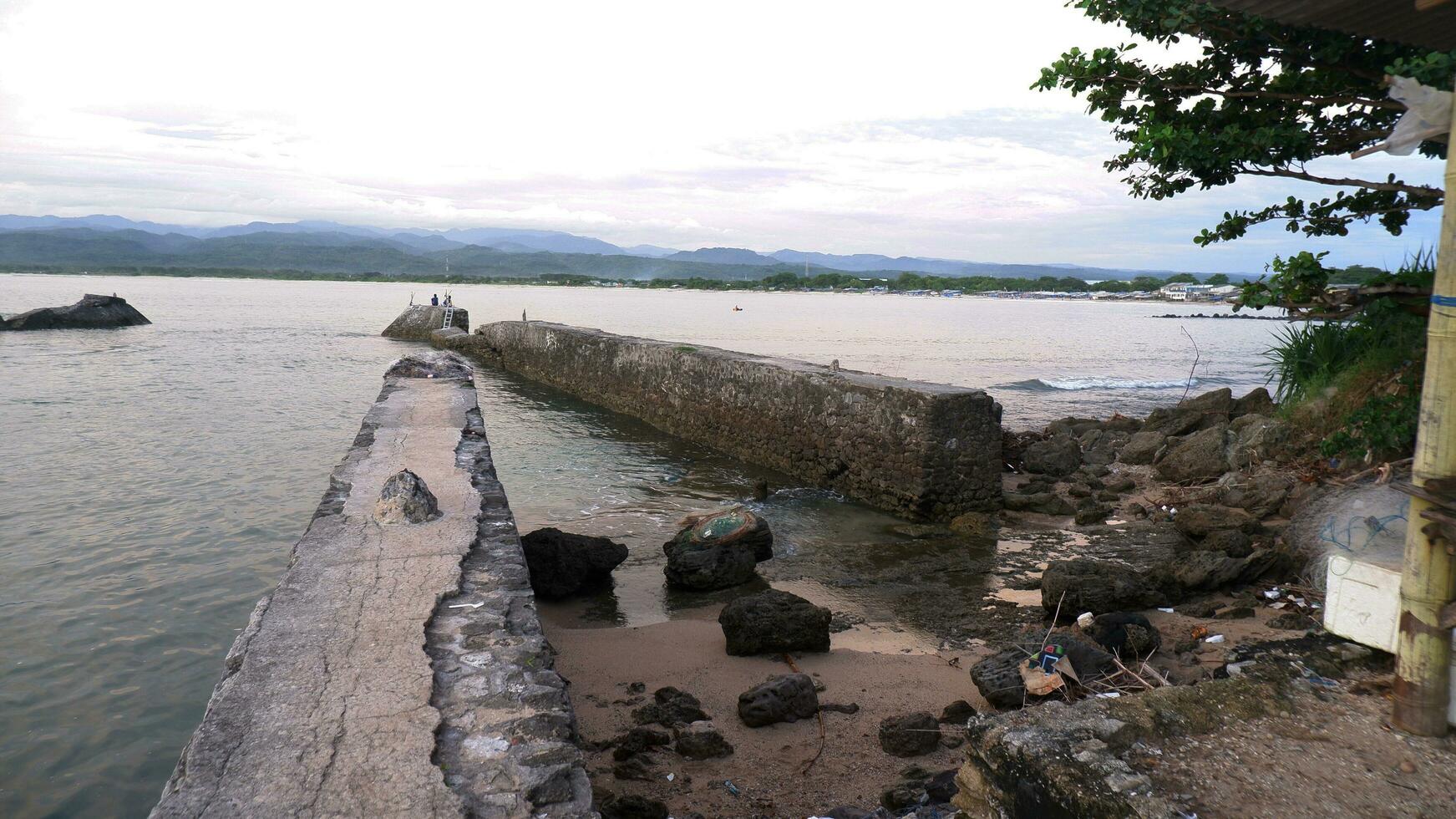 après-midi vue sur la mer et digue, plage et corail, fond de coucher de soleil sur la plage de santolo indonésie photo