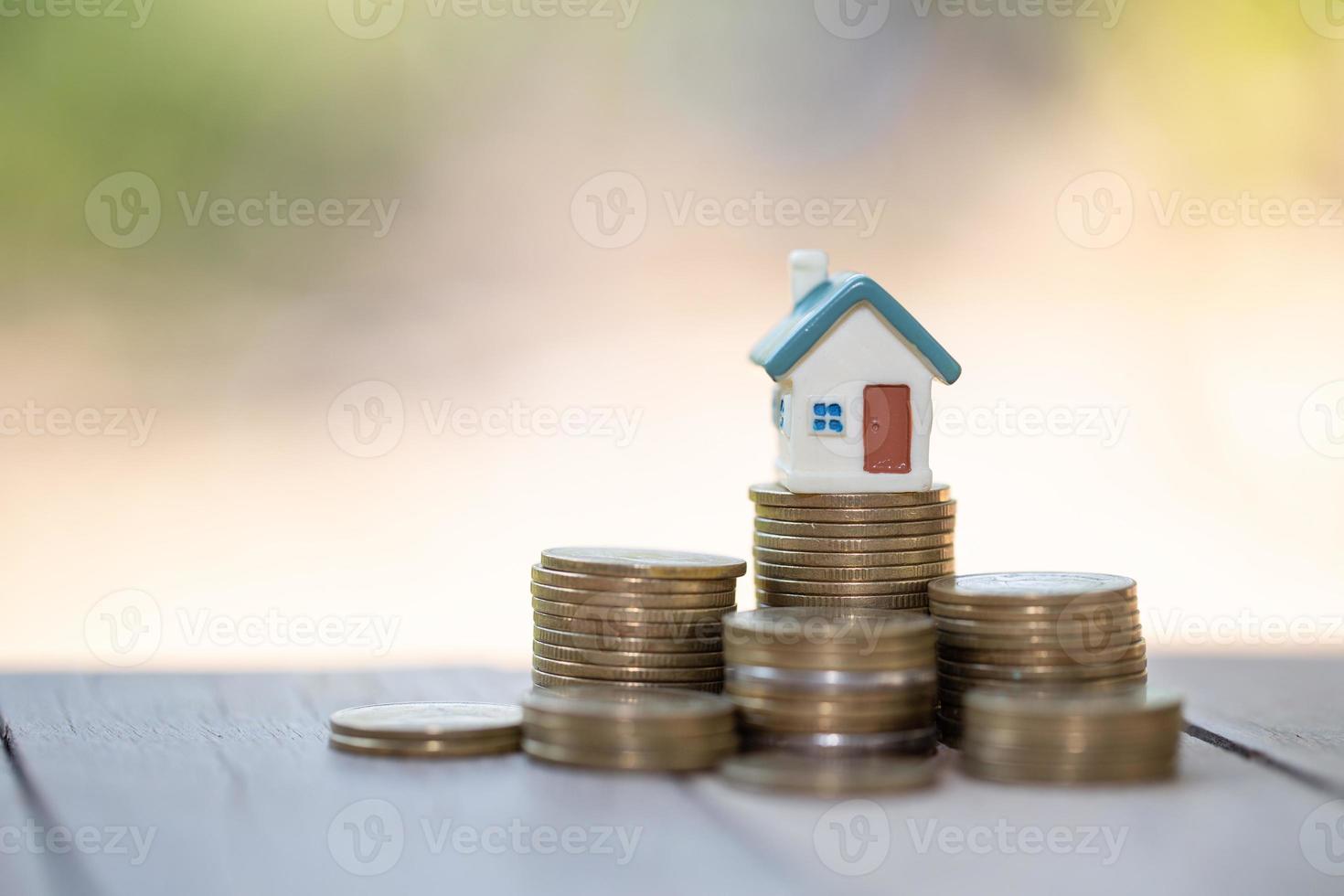 mini maison sur pile de pièces, argent et maison, hypothèque, épargne pour acheter une maison et prêt à l'investissement des entreprises pour le concept immobilier. gestion des investissements et des risques. photo