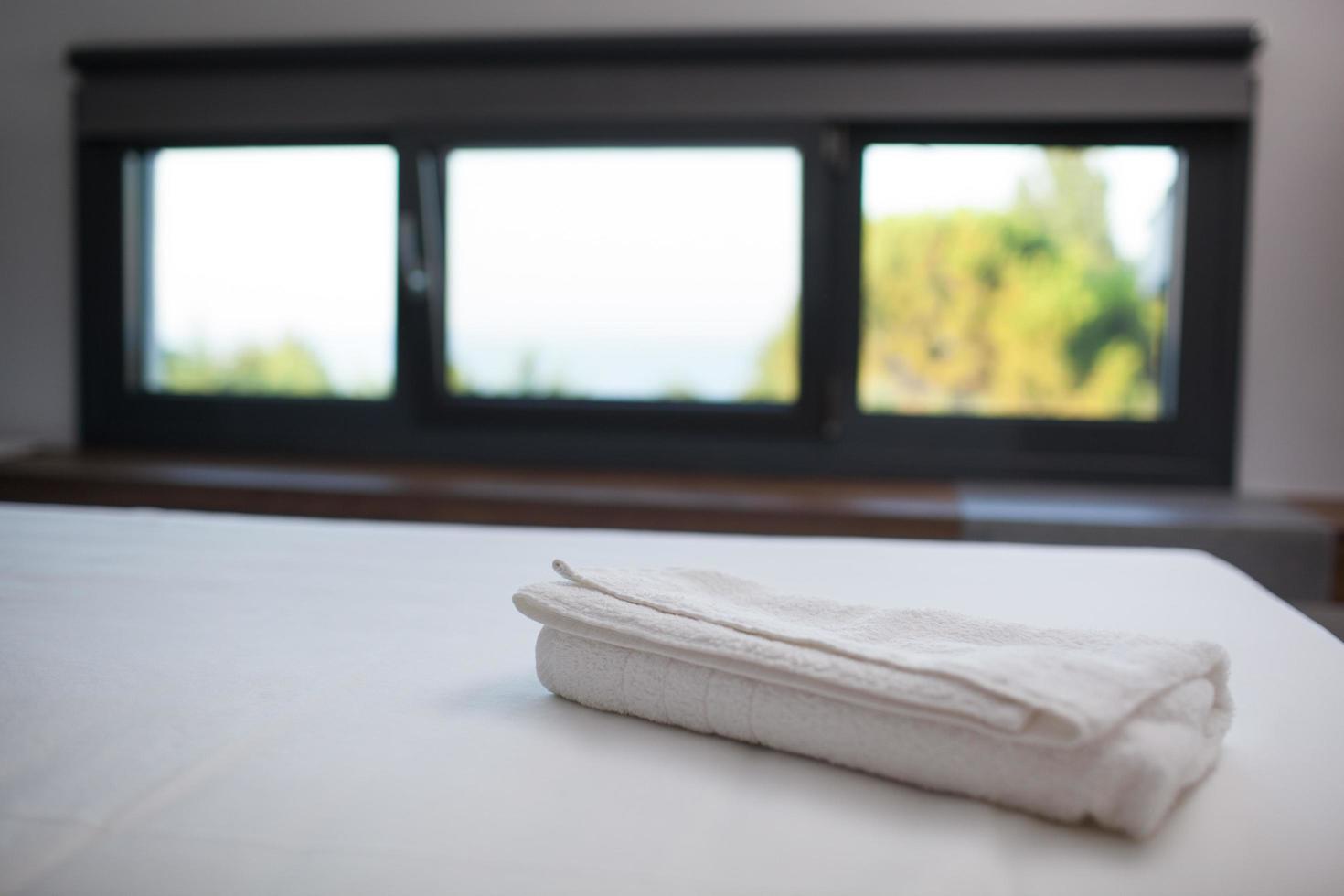 Serviette blanche propre sur le lit dans la chambre d'hôtel photo