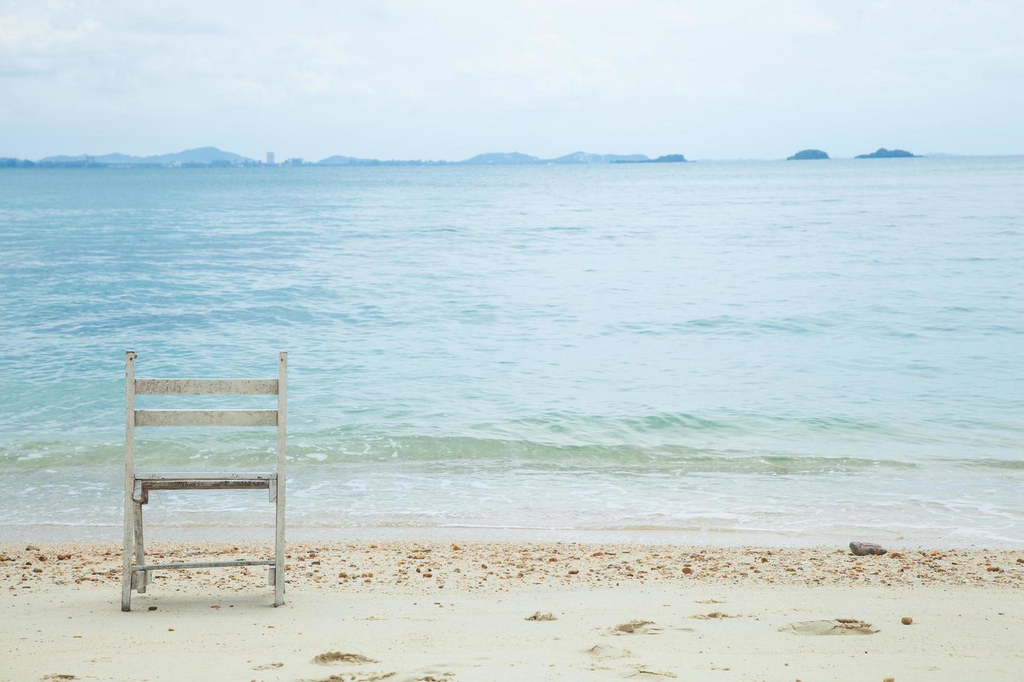 chaise en bois blanche à la mer photo