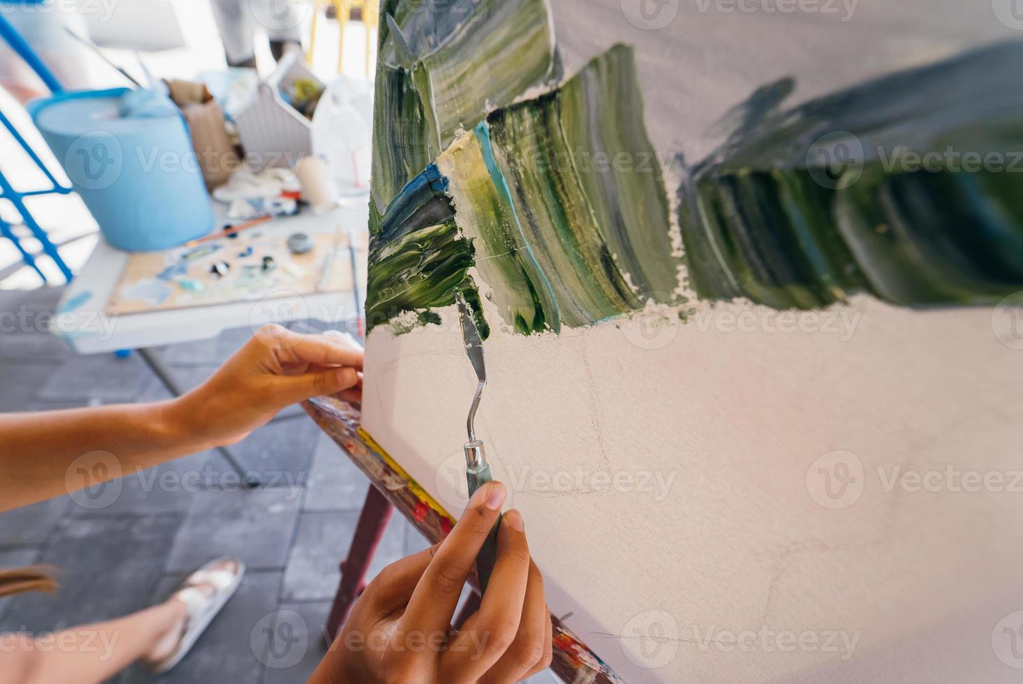 gros plan de la main d'une femme appliquant de la peinture sur une toile photo