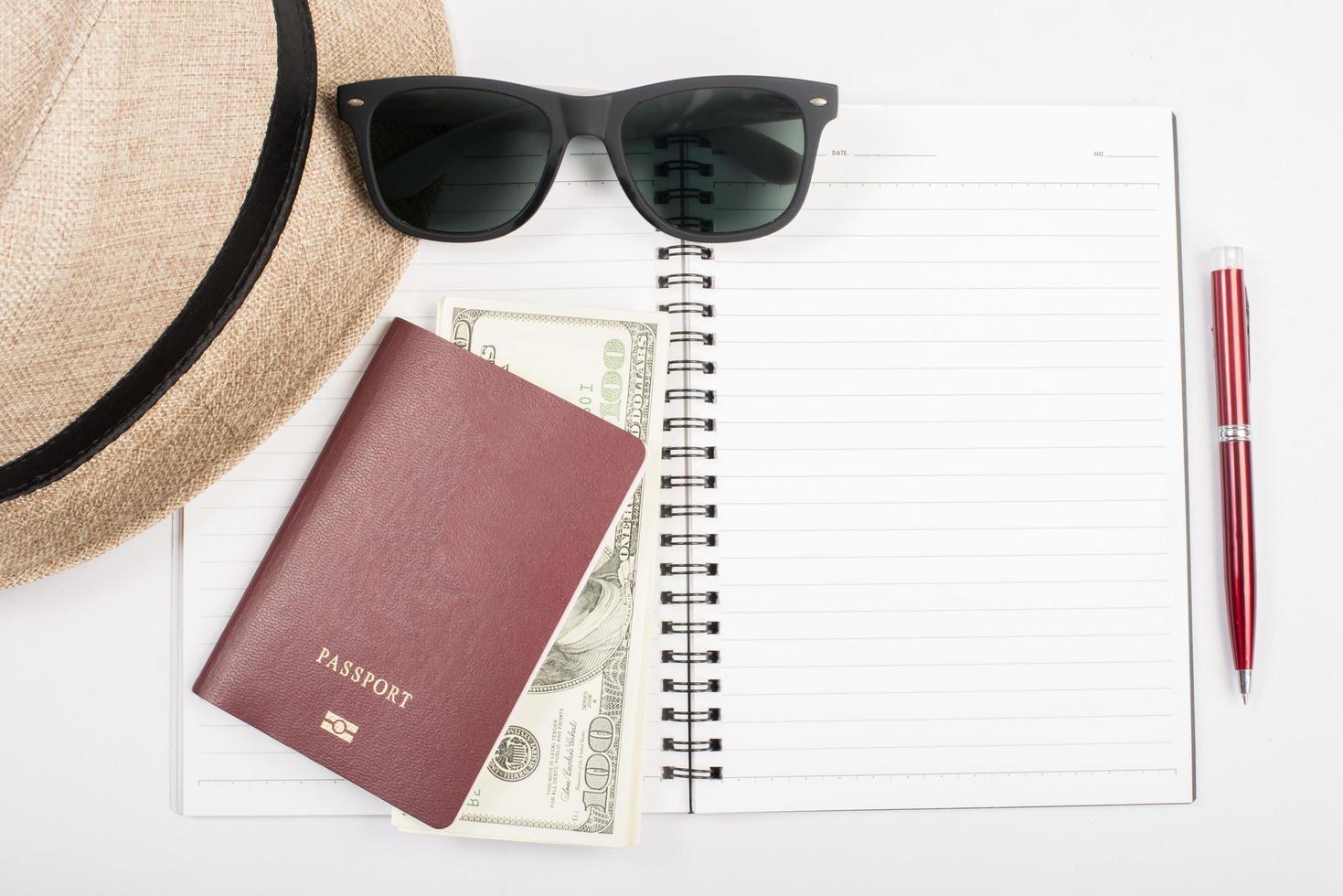 passeports, chapeau, appareil photo, lunettes et stylo sur un plancher de papier prêt à voyager photo