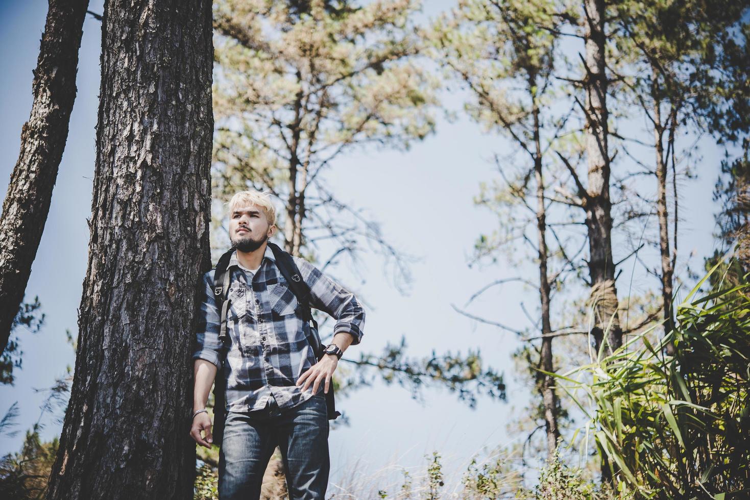 jeune homme voyageant avec un sac à dos dans la nature photo