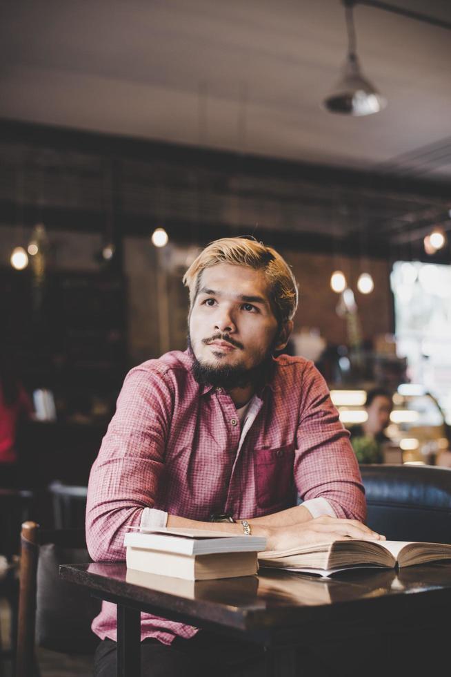 Hipster barbu livre de lecture au café. photo