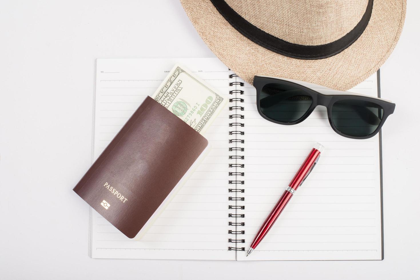 passeports, chapeau, appareil photo, lunettes et stylo sur un plancher de papier prêt à voyager photo