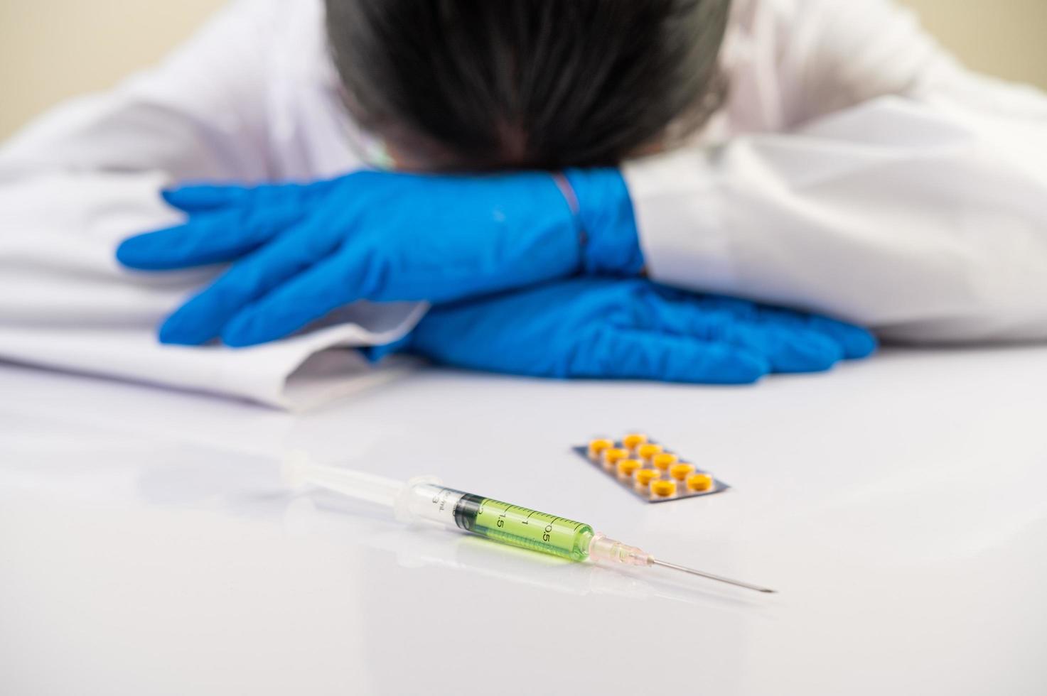 scientifique à la table avec des vaccins et des médicaments photo