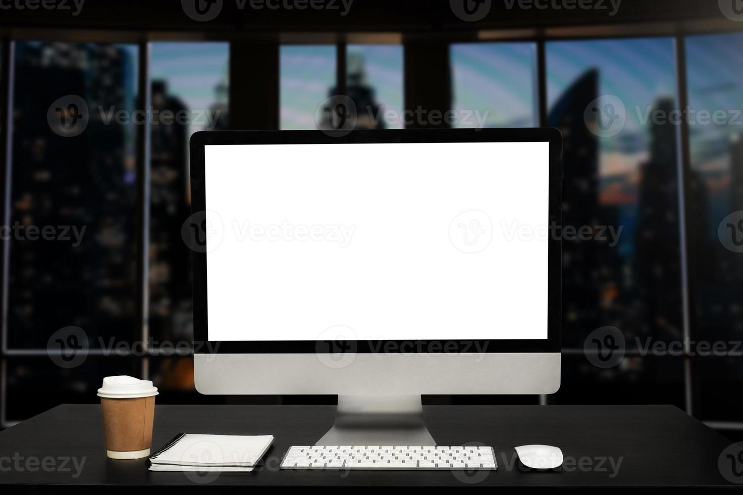 ordinateur de l'espace de travail posé sur un bureau en bois et entouré d'une tasse à café, d'un presse-papiers, d'une plante en pot, d'une pile de smartphone, d'une tablette et d'un clavier de bureau ordonné. notion d'espace de travail. photo