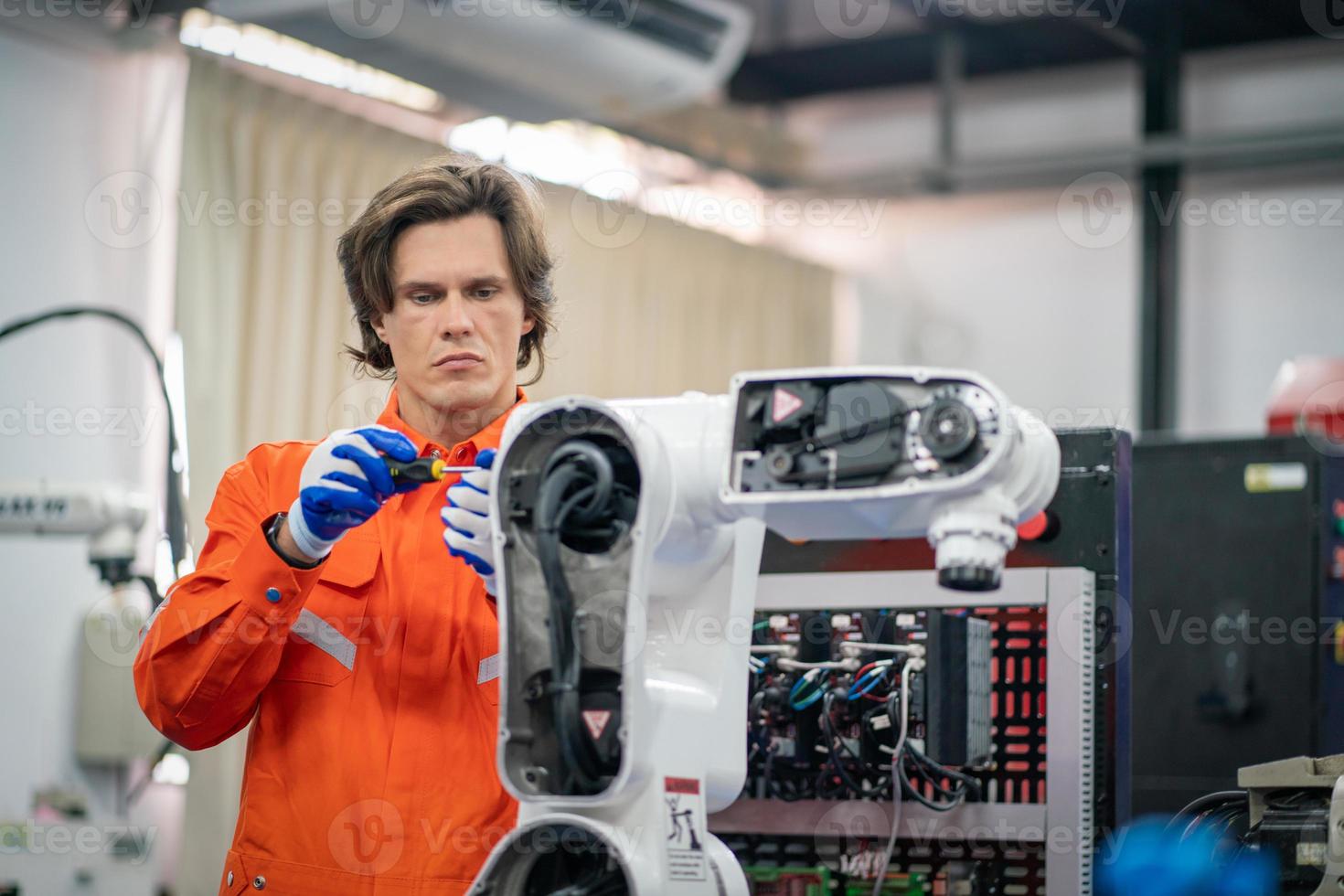 ingénierie de maintenance réparer la machine de bras robotique de soudage automatique à la ligne de production dans l'usine de l'industrie. photo