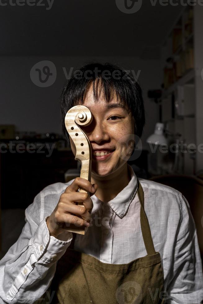 jeune luthier chinois au travail dans son atelier photo