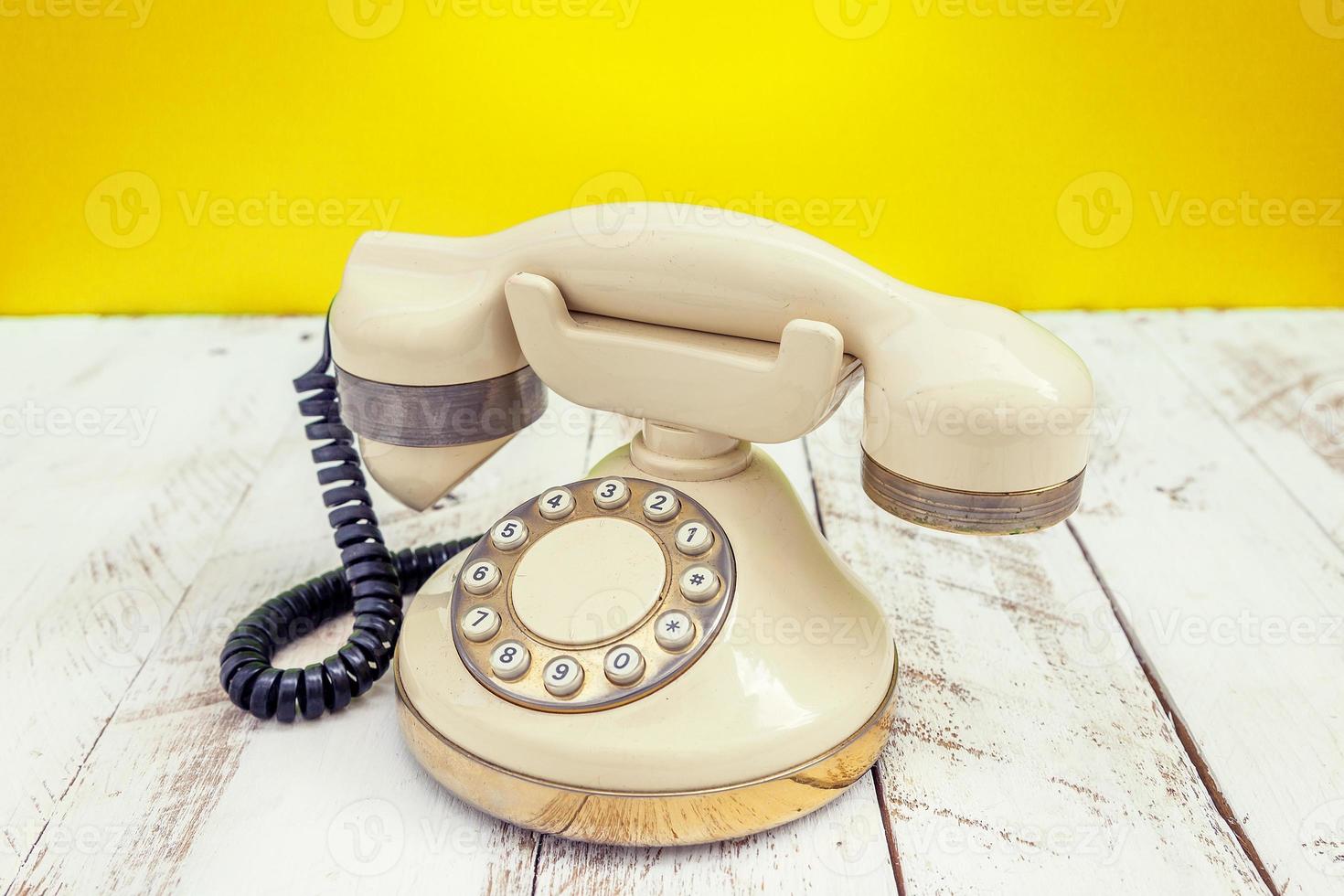 téléphone vintage coloré ivoire sur une table en bois blanc photo